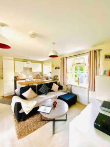 een woonkamer met een bank en een tafel bij The Willow Studio - peaceful retreat near Whitstable seaside in Kent