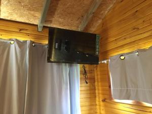 a flat screen tv in a room with white curtains at Bahía in Punta Del Diablo