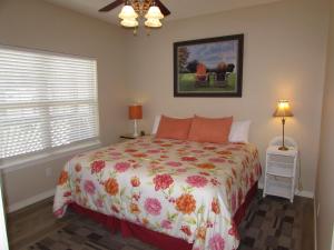 a bedroom with a bed with a floral bedspread at Walk-in Condo A-4 in Hollister
