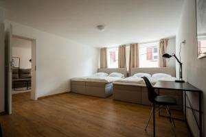 1 dormitorio con 2 camas y escritorio con silla en Old Town Apartment 2 rooms/baths, en Düsseldorf