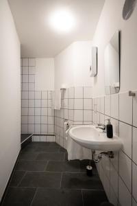 un lavabo blanco en un baño de azulejos blancos en Old Town Apartment 2 rooms/baths, en Düsseldorf