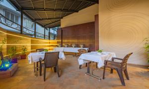 un restaurant avec deux tables et des chaises avec des nappes blanches dans l'établissement Treebo Tryst Savera Inn, à Mumbai