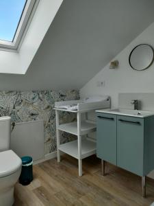 uma casa de banho com um lavatório e um WC em L'intemporelle em Le Crotoy