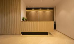 a lobby with a yellow wall with plants on it at Treebo Tryst Savera Inn in Mumbai