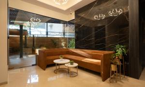 a living room with a brown couch and a table at Treebo Tryst Savera Inn in Mumbai