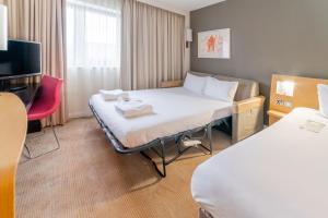 ein Hotelzimmer mit einem Bett und einem TV in der Unterkunft Novotel Southampton in Southampton