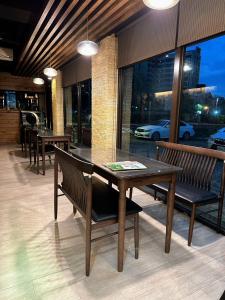 uma sala de jantar com mesas e bancos e um edifício em 沐-湯宿溫泉行旅 em Jiaoxi