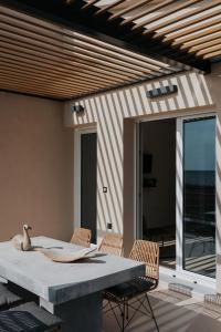 a patio with a table and chairs on a patio at Ponte Suites in Antirrio