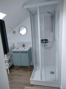 uma casa de banho com um chuveiro e um lavatório. em L'intemporelle em Le Crotoy