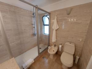 La salle de bains est pourvue d'une douche et de toilettes. dans l'établissement Ancão Beach Apartment, à Almancil