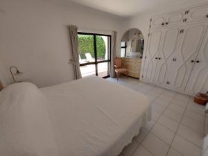阿爾馬西爾的住宿－Ancão Beach Apartment，白色的卧室设有白色的床和窗户。