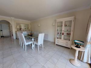 a kitchen and dining room with a table and chairs at Ancão Beach Apartment in Almancil