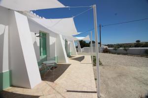 - Vistas a una casa blanca con sombrilla en Herdade de Alagães, en Mértola