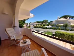 a balcony with chairs and a view of a garden at Ancão Beach Apartment in Almancil