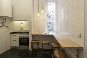 une cuisine avec un comptoir en bois et des tabourets dans l'établissement Downtown Flat with Design and Comfort at Downtown, 3rd-floor no lift, à Lisbonne