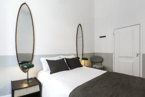 - une chambre avec un lit et deux miroirs dans l'établissement Downtown Flat with Design and Comfort at Downtown, 3rd-floor no lift, à Lisbonne