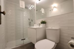 une salle de bain blanche avec toilettes et douche dans l'établissement Chic Urban Retreat at Downtown with Balcony & Views, 5th-floor no lift, à Lisbonne 20 autres photos