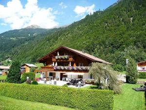 a house in the middle of a field with a mountain at Landhaus Rudigier in Sankt Gallenkirch