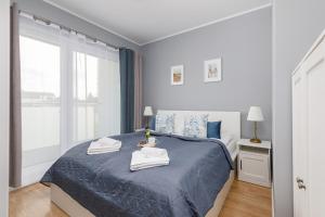 a bedroom with a blue bed with towels on it at Apartamenty Sunset Resort by Renters in Grzybowo