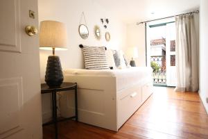 une chambre avec un lit et une table avec une lampe dans l'établissement Chic Urban Retreat at Downtown with Balcony & Views, 5th-floor no lift, à Lisbonne