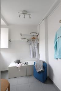 Cette chambre blanche dispose d'une table et d'une robe accrochée au mur. dans l'établissement Chic Urban Retreat at Downtown with Balcony & Views, 5th-floor no lift, à Lisbonne