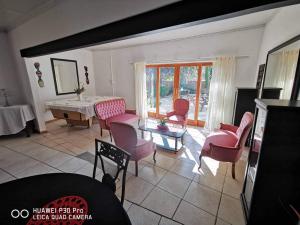 uma sala de estar com cadeiras cor-de-rosa e uma mesa em Akkerdam Bed and Breakfast em Calvinia