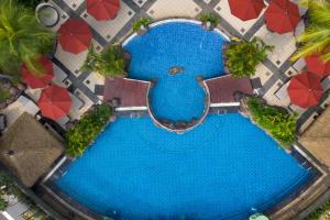 einen Blick über einen Pool mit roten Sonnenschirmen in der Unterkunft Hotel Ciputra Jakarta managed by Swiss-Belhotel International in Jakarta