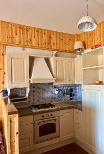 cocina con armarios blancos y fogones en MAGAVE's House, en Campo di Giove