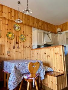una cucina con tavolo e parete in legno di MAGAVE's House a Campo di Giove