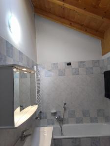 a bathroom with a tub and a sink and a bath tub at casetta Vittorio in Mezzolago