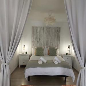 1 dormitorio blanco con 1 cama grande y 2 mesitas de noche en Apto en el Centro, junto a la playa, Marbella, en Marbella