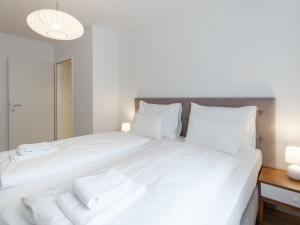 una camera da letto con un grande letto bianco con asciugamani di MyFavorit by Duschel Apartments Vienna a Vienna