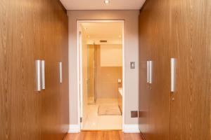 baño con puertas de madera y ducha a ras de suelo en Modern Beachfront Eden on the Bay 210- 2 bedroom, 2 bathroom, en Bloubergstrand 26 fotos más