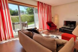 salon z kanapą i telewizorem w obiekcie Modern 3Bedroom Duplex W/Pool by LovelyStay w mieście Alcantarilha