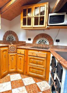 eine Küche mit Holzschränken und einer Waschmaschine in der Unterkunft Casa Gianmoena in Cavalese