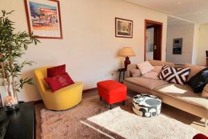 sala de estar con sofá y taburete rojo en Modern 3Bedroom Duplex W/Pool by LovelyStay en Alcantarilha