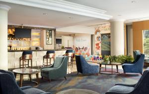 un vestíbulo con sillas y un bar en Hotel Ciputra Jakarta managed by Swiss-Belhotel International, en Yakarta