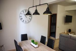 a dining room with a table and a clock on the wall at MI CAPRICHO in Santa Cruz de la Palma