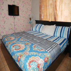 sypialnia z łóżkiem z niebieską kołdrą w obiekcie Arsenal's Lodge w mieście Abudża