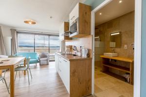 a kitchen with a table and a dining room with a view at Appart'Hôtel Les Lofts du Grand Lac de Lozère in Langogne +37 photos