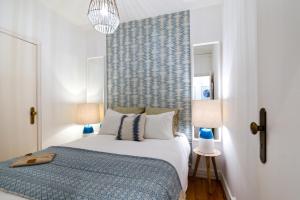 een slaapkamer met een groot bed en 2 lampen bij Chic Urban Apartment at Downtown with a Sunny Balcony! in Lissabon