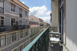 een balkon met uitzicht op een straat met gebouwen bij Chic Urban Apartment at Downtown with a Sunny Balcony! in Lissabon