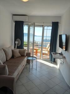 ein Wohnzimmer mit einem Sofa und Meerblick in der Unterkunft Koi Seaview apartment in Herceg-Novi