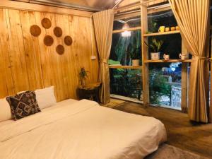 sypialnia z łóżkiem i dużym oknem w obiekcie Queen's Homestay Ba Vì - Venuestay w mieście Ba Vì District