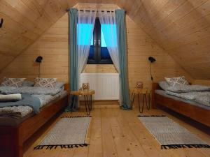 a attic room with two beds and a window at Pod Grapą in Zubrzyca Górna