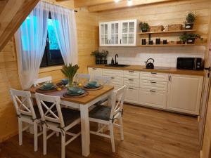 eine Küche mit einem Tisch und Stühlen in einer Hütte in der Unterkunft Pod Grapą in Zubrzyca Górna