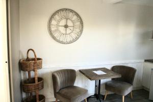 a table and two chairs and a clock on the wall at Fleur de Ré in Loix