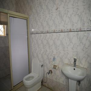 a bathroom with a toilet and a sink at Arsenal's Lodge in Abuja