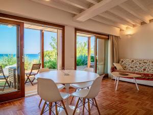a living room with a table and chairs and a couch at Villa Tanaquilla in Baratti