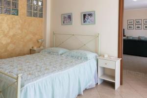 1 dormitorio con cama, mesa y espejo en Holidaycasa Circe - Con giardino vista mare, en Terracina